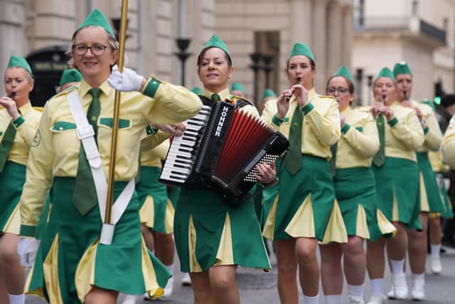 Men dressed as giant leprechauns handed out bags of Tayto crisps to children as they watched the bagpipes, drumming, dancing and songs during the colourful parade which included dignitaries and grassroots organisations from the Irish community, including Travellers.