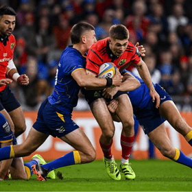 Jack Crowley, of Munster Rugby, is tackled by Sam Prendergast, left, and Jordan Larmour of Leinster, during their URC clash at Croke Park earlier this season