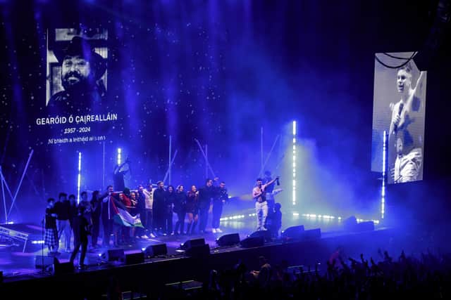 A photo of Mr O Caireallain, father of bandmate Moglai Bap – whose real name is Naoise O Caireallain – was projected onto a screen alongside the dates 1957-2024.