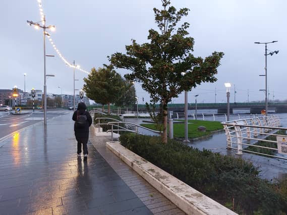 A woman walking by the river Shannon in Limerick city this Monday morning