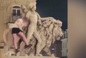 In the video, the man can be seen climbing down the statue before part of it breaks