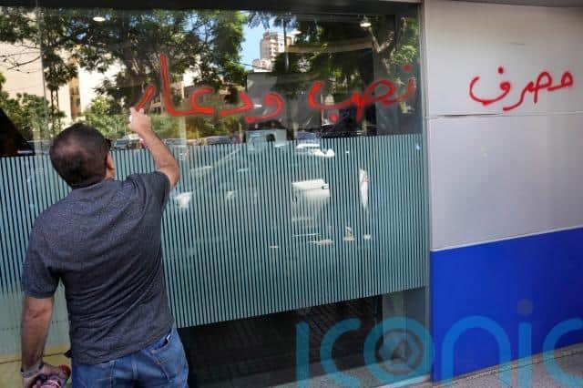 Nadine Nakhal, a bank customer, said the intruders “doused gasoline everywhere inside and took out a lighter and threatened to light it”.