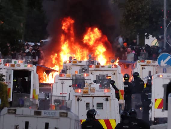 Protesters set fire to a barricade as police block Antrim Road, at the Sandyknowes roundabout in Newtownabbey