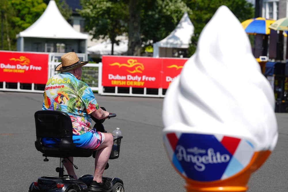 A racegoer passes by an ice cream advertising cone at the Curragh Racecourse in Curragh in Co Kildare